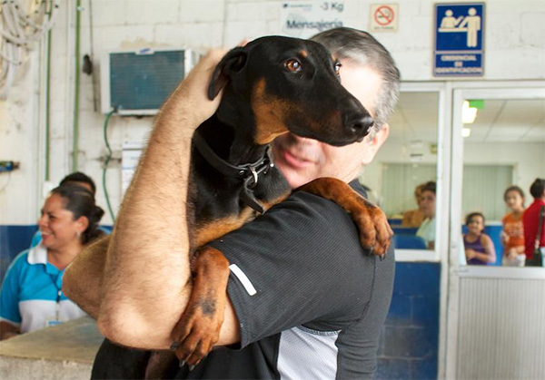 Hector hugging Chica the Doberman